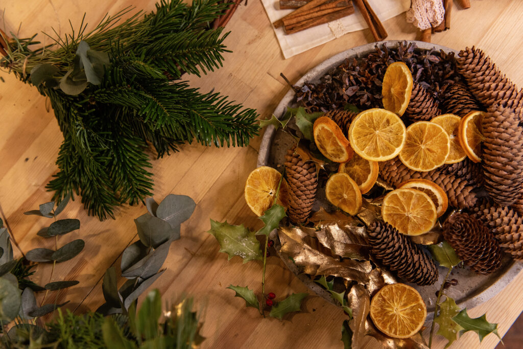 Pine and pinecones with dried oranges for festive holiday decoration ideas for table and home, interior design ideas for the holidays 